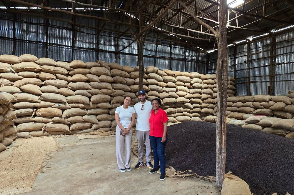 Mother and Daughter stand next to Felix in one of their holding warehouses. 